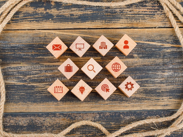 Foto gratuita concetto di gestione con blocchi di legno con icone sul tavolo di legno laici piatta.