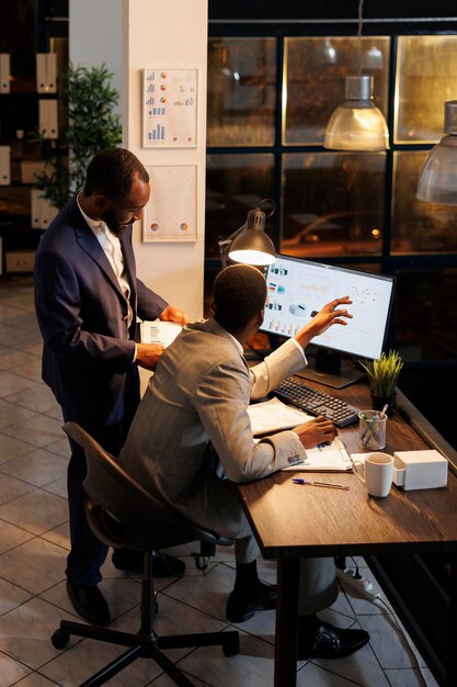 Manager analyzing financial growth report with coworker