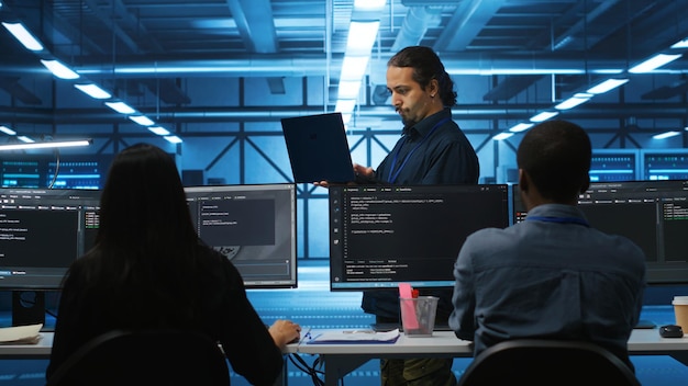 manager reading paperwork on laptop verifying infrastructure documents