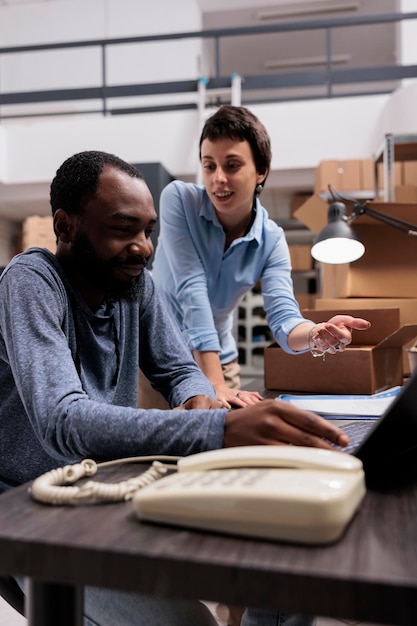 Free photo manager and supervisor looking at cargo stock analyzing transportation logistics on laptop computer, discussing online orders before start preparing packages. warehouse job concept