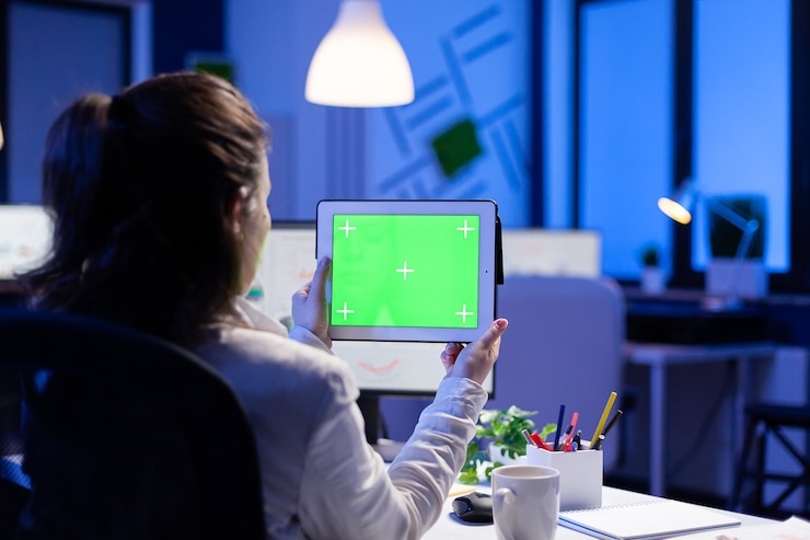 Free Photo manager woman holding tablet with green screen monitor during online web conference