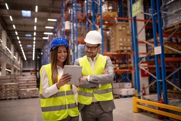 Managers controlling distribution and checking inventory in warehouse storage