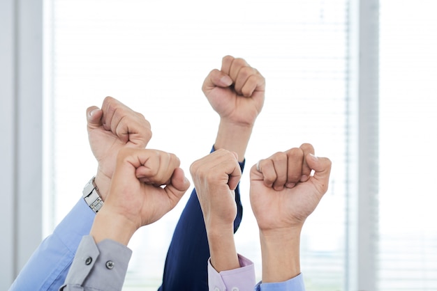 Бесплатное фото Менеджеры, показывающие сжатые кулаки