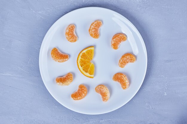 Mandarin and oranges in a white plate.