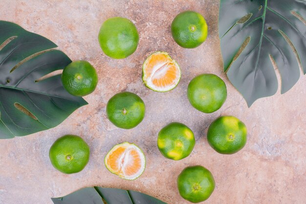 Mandarines on a surface with green leaves