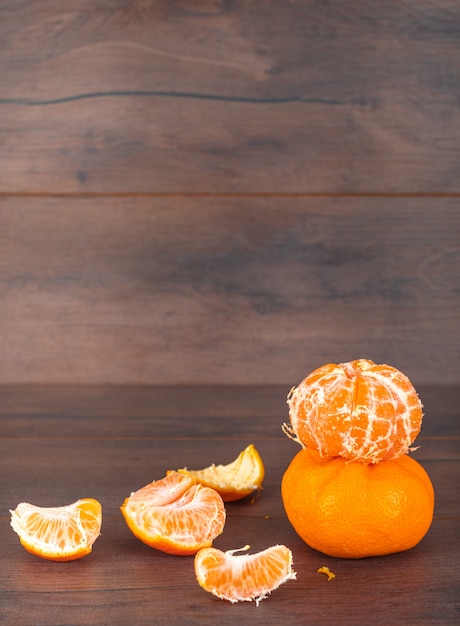 Mandarini isolati sulla vista laterale degli agrumi di superficie di marrone