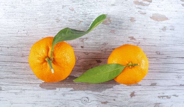 Mandarins with leaves on wooden  surface