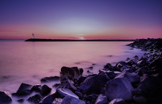 Tramonto mangnifico ad una possibilità remota della riva di mare