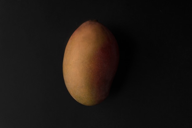 Плод манго на черном