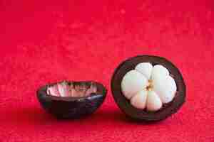 Free photo mangosteen thai popular fruits - a tropical fruit with sweet juicy white segments of flesh inside a thick reddish-brown rind.