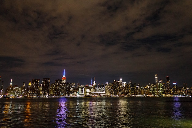 무료 사진 밤에 맨하탄 강 반사와 멀리에서 촬영