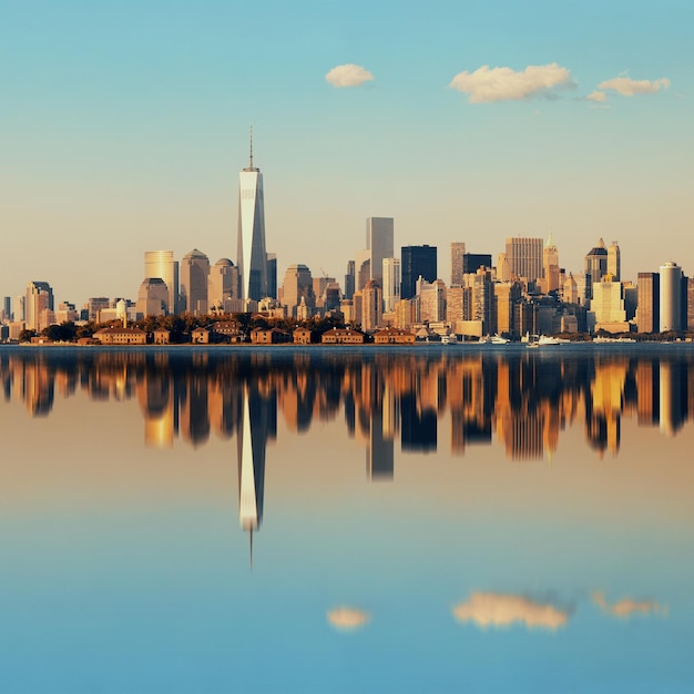 Городской горизонт Манхэттена с городскими небоскребами над рекой с отражениями.