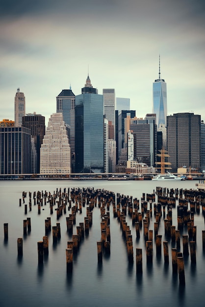 Manhattan financial district with skyscrapers and abandoned pier over East River.