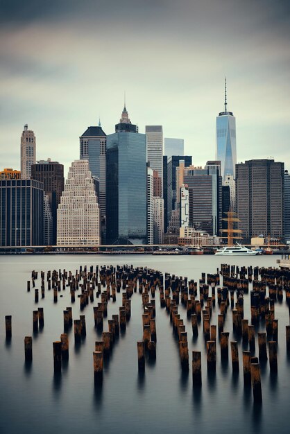 Manhattan financial district with skyscrapers and abandoned pier over East River.