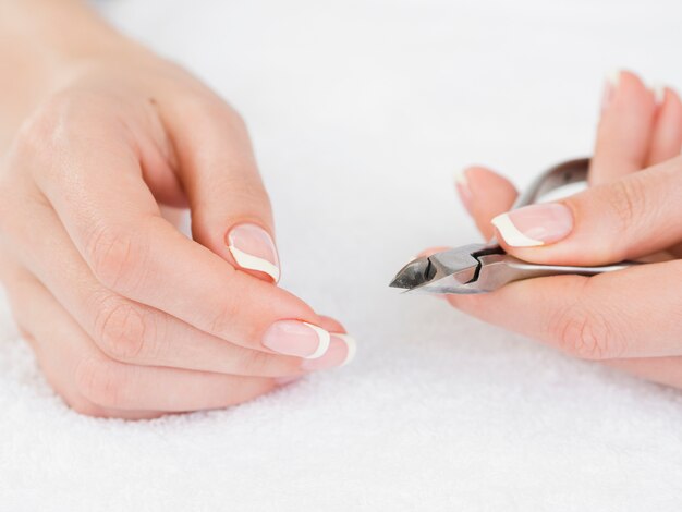 Manicured hands holding nail clipper