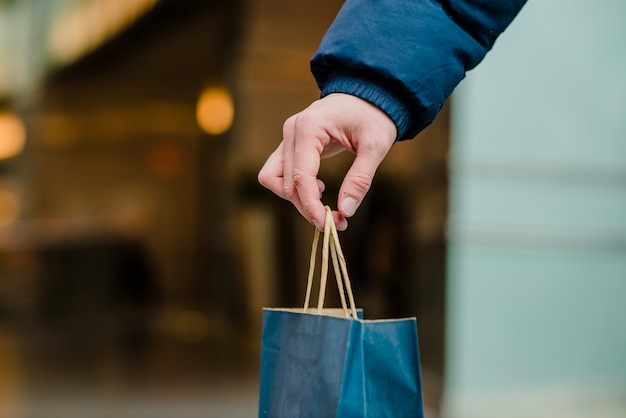 Mans hand holding shopping bag