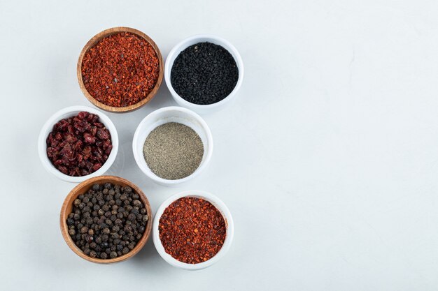 Many bowls of spices on a white background. 