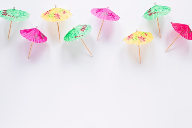 Many bright cocktail umbrellas on table