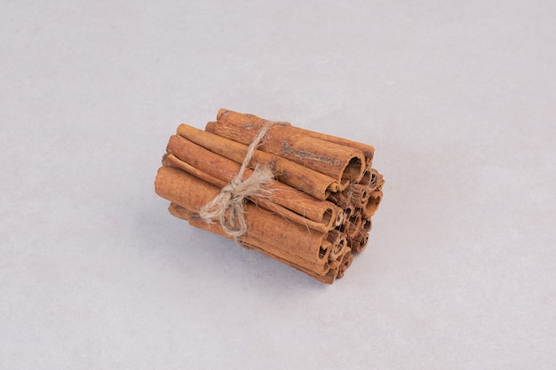 Many of cinnamon sticks on white surface