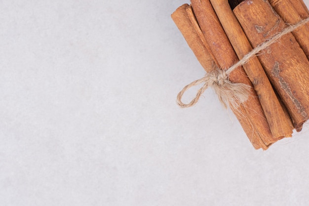 Many of cinnamon sticks on white table