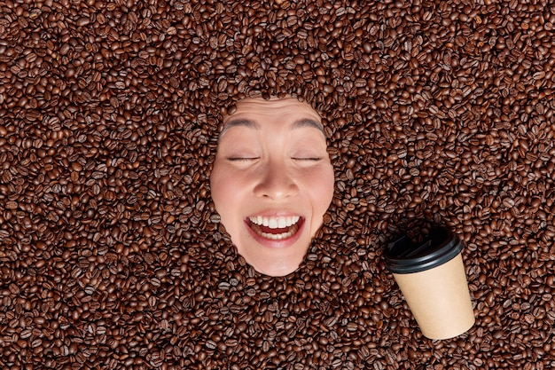 무료 사진 음료 주변에 많은 커피 콩 종이 일회용 컵에서 나온 에스프레소 눈을 감고 미소 활짝 즐거운 향기나 향기를 즐긴다
