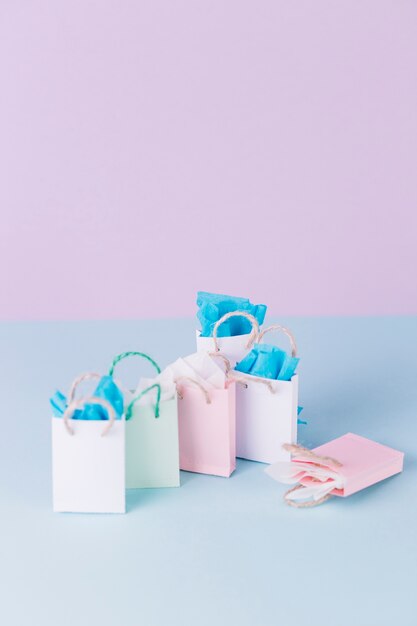Many colorful paper shopping bags on blue surface