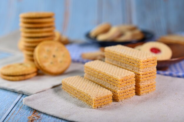 多くのクッキーは生地に置かれ、木製のテーブルに置かれます。