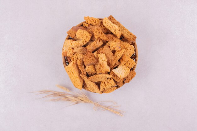 Many of crackers on basket with ear of wheat.