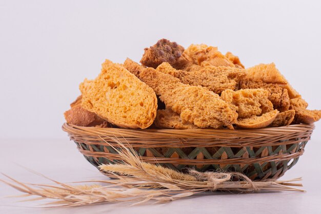 Many of crackers on basket with ear of wheat.