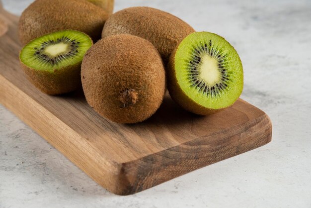 Many of delicious kiwi fruits on wooden board. 