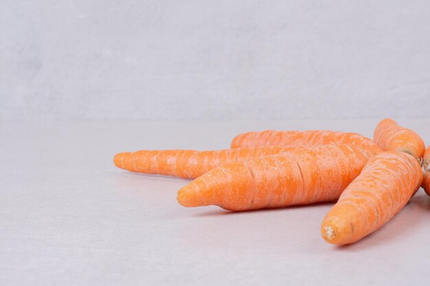 Many of fresh carrots on white table