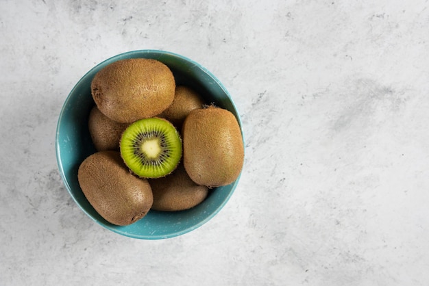 Free photo many of fresh kiwi fruits on blue bowl.