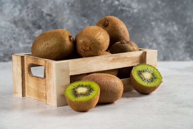 Many of fresh kiwi fruits on wooden basket.