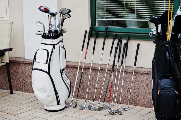 Many golf clubs in bag at pavement