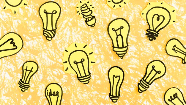 Many hand drawn yellow light bulbs on yellow background