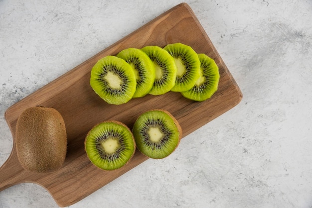 Many of kiwi fruits slices on wooden board. 