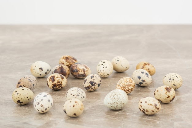 Многие перепелиные яйца на мраморной поверхности