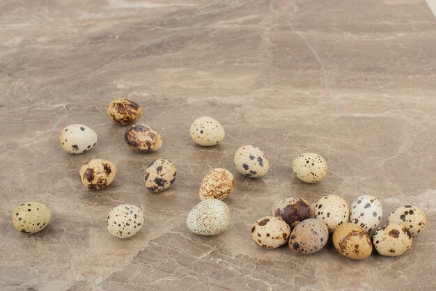 Many of quail eggs on marble table .