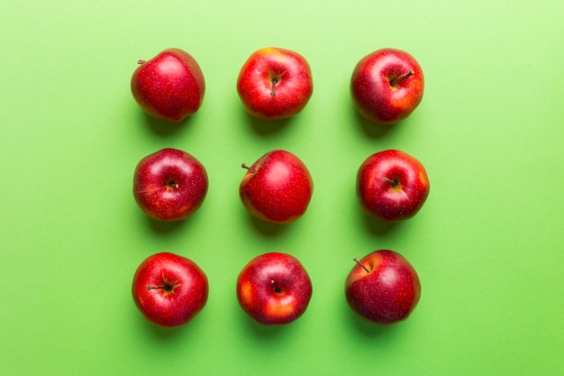 Many red apples on colored background top view autumn pattern with fresh apple above view