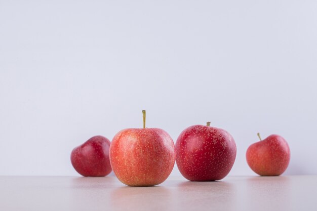 Many of red, sweet apple on white.