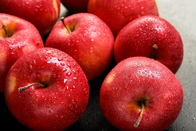 Многие спелые сочные красные яблоки, покрытые каплями воды крупным планом, селективный фокус спелых фруктов в качестве фона