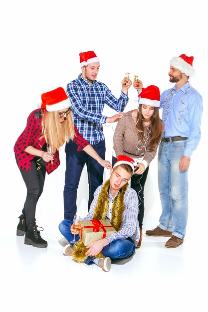 Many young women and men drinking at christmas party on white studio background