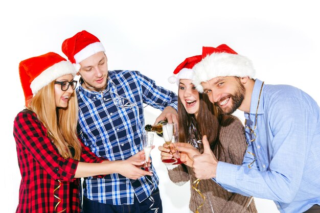 多くの若い女性と白いスタジオのクリスマスパーティーで飲む男性