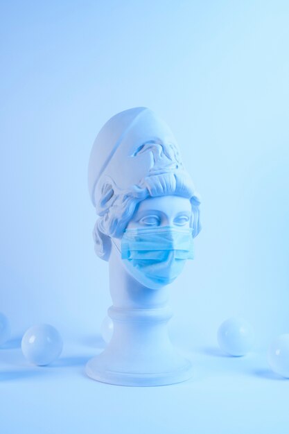 Marble sculpture of historical figure with medical mask and balls