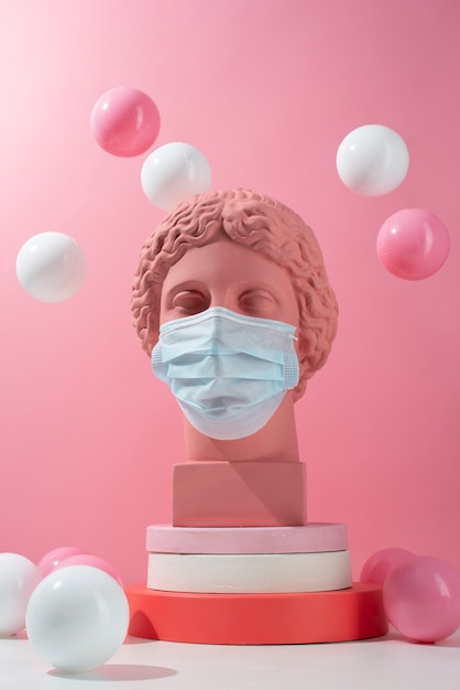 Marble sculpture of historical figure with medical mask and balls