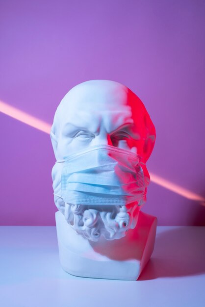 Marble sculpture of historical figure with medical mask