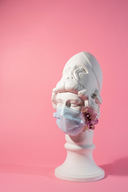 Marble sculpture of historical figure with medical mask