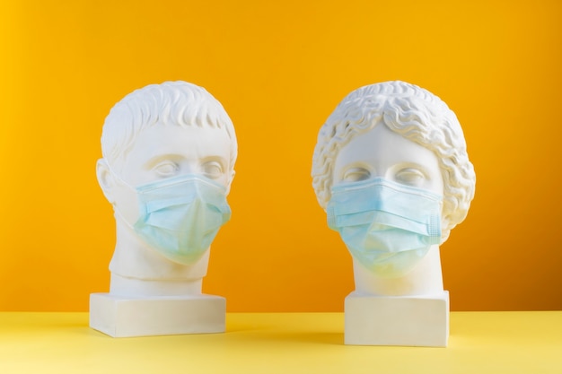 Marble sculptures of historical figures with medical masks