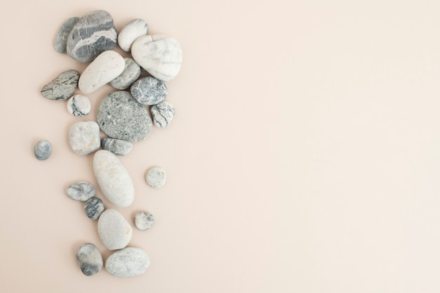 Free photo marble zen stones stacked on beige background in mindfulness concept