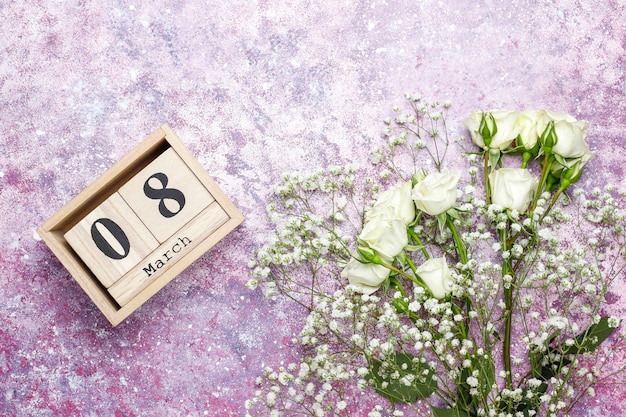 March 8 Women's Day card with white flowers,sweets and a cup of tea .